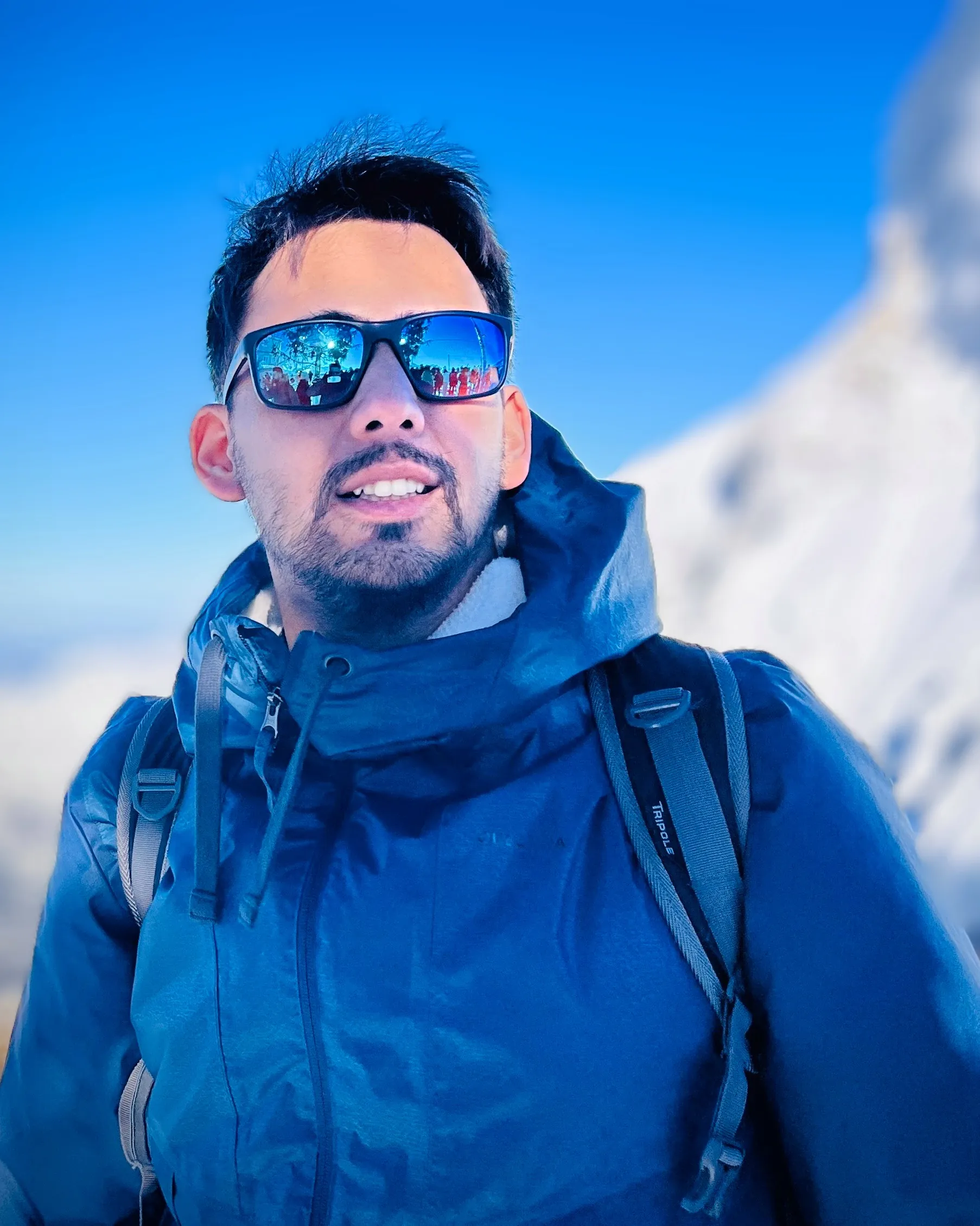 Shubham Gupta wearing sunglasses in a snowy alpine landscape