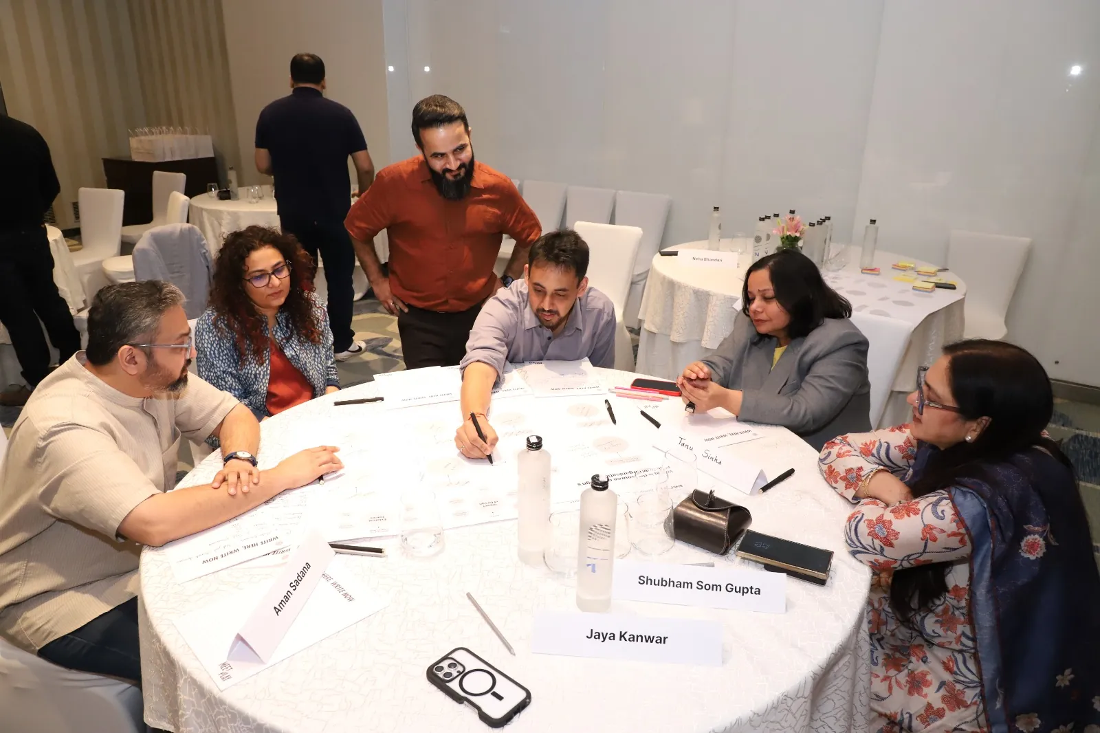 Shubham Gupta working with industry participants around a workshop table.