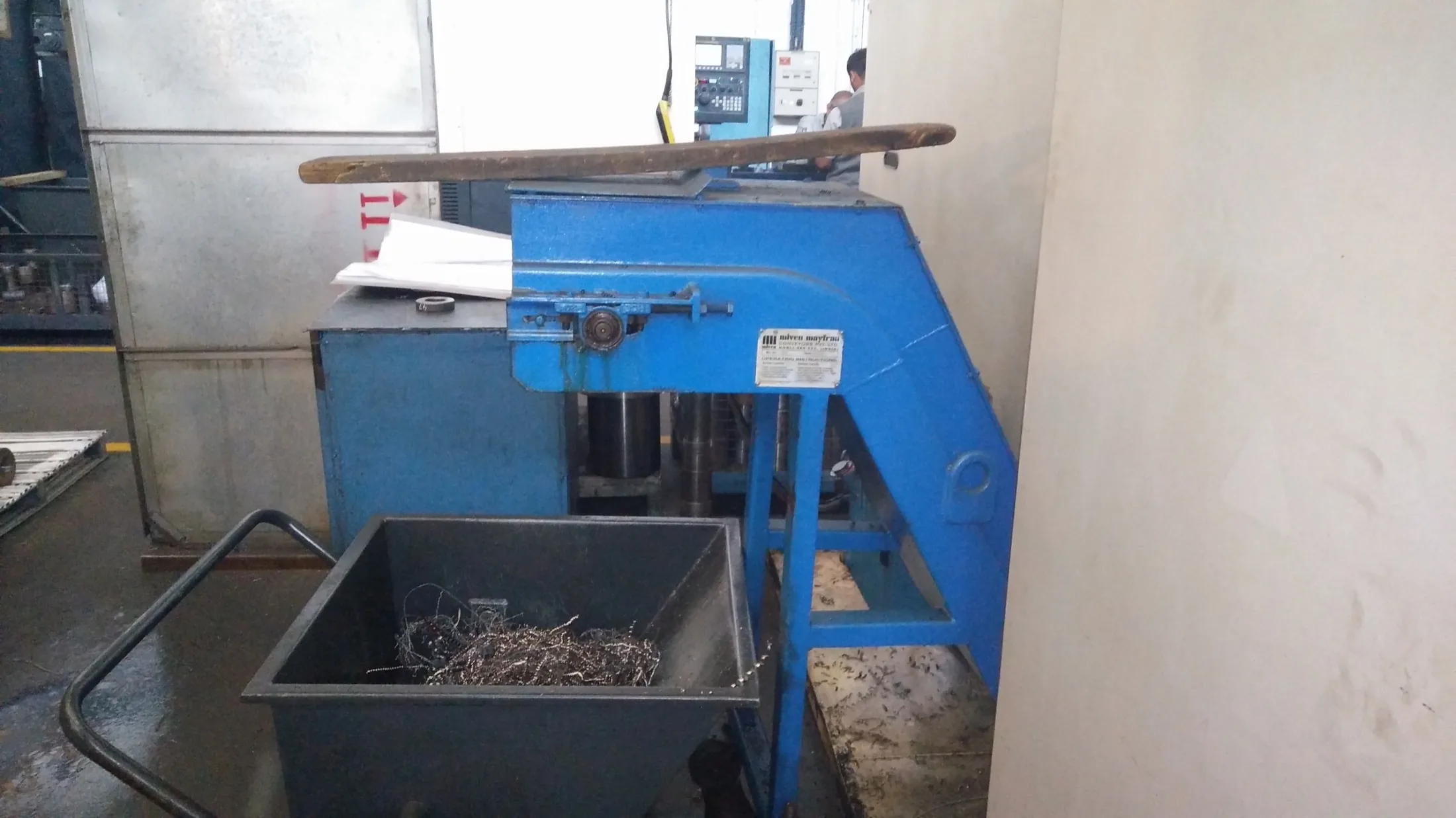 Existing blue chip conveyor discharging into an open wheeled collection bin.