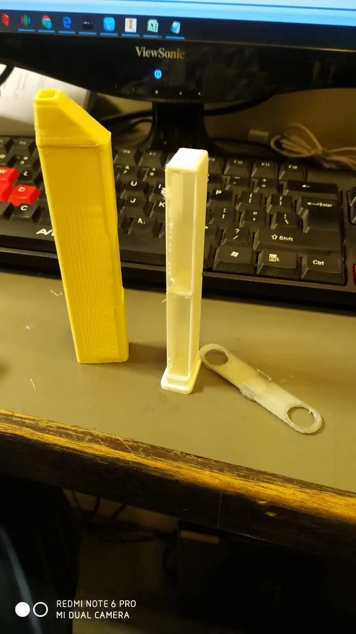 Separated yellow and translucent toothbrush-prototype components beside a workstation.