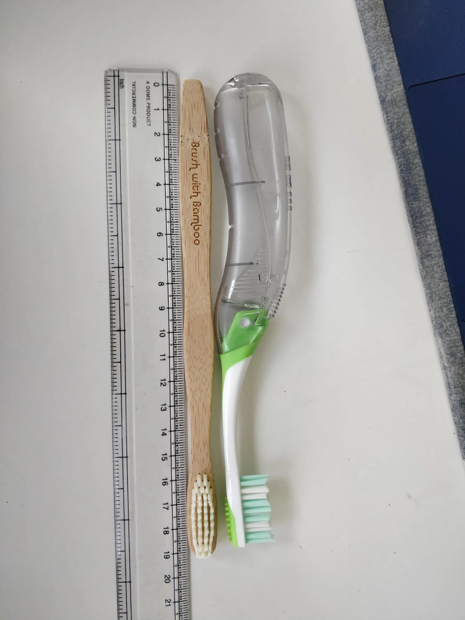 Two toothbrush forms placed beside a ruler for length comparison.